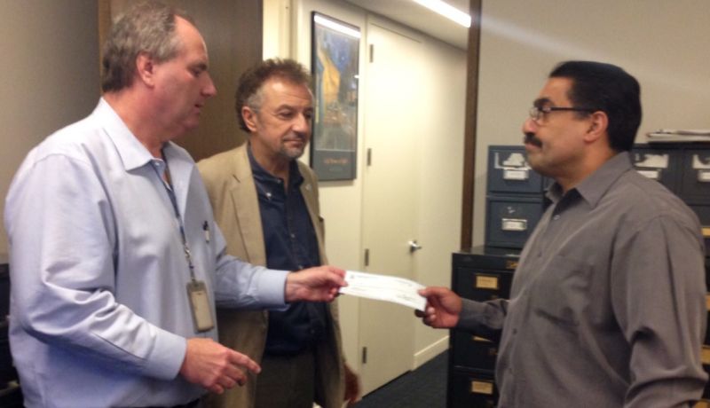 Guild President Bill O'Meara and Secretary-Treasurer Peter Szekely present El Diario Unit Chair Oscar Hernandez with $3830 on March 14 to match the amount El Diario colleagues raised for Liseth Perez, whose husband died in Wednesday's building explosion.